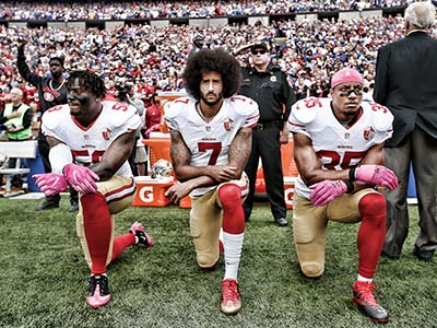 Kaepernick and teammates kneeling during national anthem